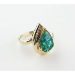 A yellow metal ring set with a synthetic mosaic opal triplet and finished with three diamonds.