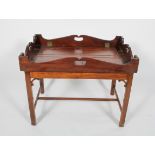 A Georgian style mahogany butlers' tray and stand, the tray with pierced handles and drop sides,