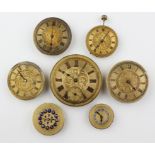 A collection of seven mechanical watch movements with dials attached.