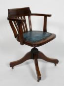 An oak Captains chair, the lathe back above a padded seat, adjustable base with four scrolling legs,