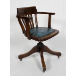 An oak Captains chair, the lathe back above a padded seat, adjustable base with four scrolling legs,