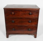 A George III mahogany chest of three cock beaded graduated drawers, with turned pulls,