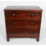 A George III mahogany chest of three cock beaded graduated drawers, with turned pulls,