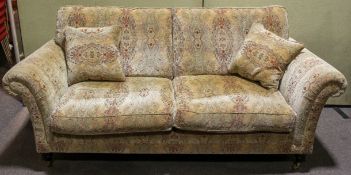 A modern Parker Knoll sofa, with loose cushions, in a scrolling foliate upholstery,