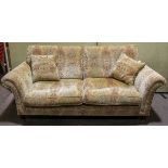 A modern Parker Knoll sofa, with loose cushions, in a scrolling foliate upholstery,