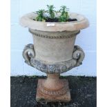 A buff terracotta garden urn, of waisted form with a pair of scroll handles and socle base,