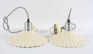A pair of moulded cream ware ceiling light shades, of ripple form, being re-wired,