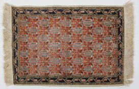 A silk piled rug, probably Kashmiri, with a lattice field enclosed by narrow borders,