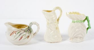 Three Belleek Parian jugs, comprising : a shell shaped example,