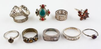 A collection of eight rings of variable designs, size ranges from J to R and a scarf ring.