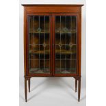 An Edwardian walnut and satinwood inlaid display cabinet, with leaded glass doors,