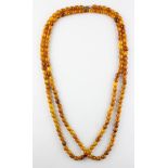 A single strand of uniform oval orange beads of varying shades.