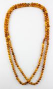 A single strand of uniform oval orange beads of varying shades.