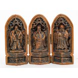 A Chinese carved tryptych, cast as three Immortals in niches,