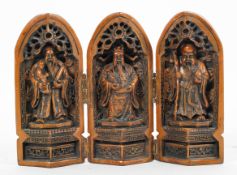 A Chinese carved tryptych, cast as three Immortals in niches,