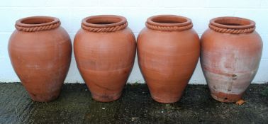 A set of four terracotta olive jar shaped jardiniere, with rope twist neck,