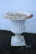 A cast iron garden urn, of waisted form with fluted decoration,