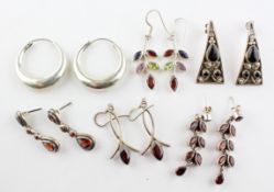 A collection of six pairs of drop earrings of variable designs. Most are marked 925 for silver.