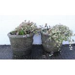 A pair of reconstituted stone planters, or circular form, with flower head decoration,