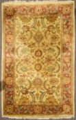 An Indian carpet, with scrolling foliage and tendrils inside a triple border,