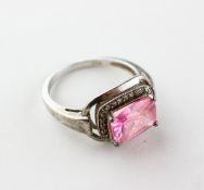 A white metal dress ring principally set with a pink cubic zirconia