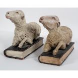 A pair of 15th century style carved wood sheep, recumbent on books,