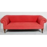 A Victorian Chesterfield sofa, with scrolling arms and back on turned walnut legs,