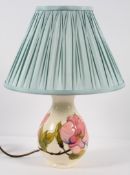 A Moorcroft table lamp of baluster form, decorated with pink magnolia on a cream ground, Stamped,