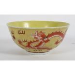 A Chinese yellow ground bowl, circa 1900, with iron red dragons chasing pearls,