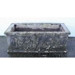 A reconstituted stone rectangular trough, with cast cherub decoration,