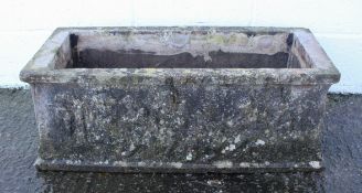 A reconstituted stone rectangular trough, with cast cherub decoration,