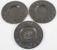 A pair of Arts and Crafts style pewter mounted copper dishes, with flowering foliage decoration,