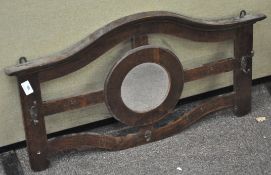 An oak wall mounted coat hook rack with central round mirror,