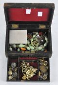 A vintage jewellery box containing a selection of costume jewellery,