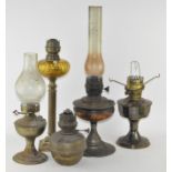 A group of five oil lamps,of varying sizes and conditions,