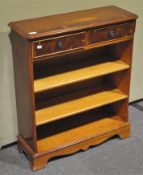 A modern yew wood bookcase, with three shelves under two drawers,