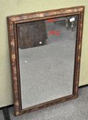 A wall mirror of rectangular form, the wooden frame adorned with floral decoration, bevelled edge,