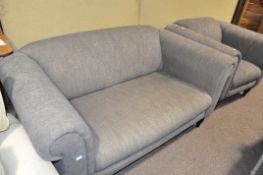 A modern grey upholstered sofa with matching armchair,