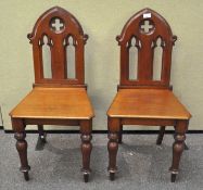 A pair of small late 19th century mahogany Gothic hall chairs,