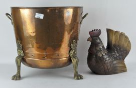 A copper and brass cauldron shaped log basket, raised upon three feet,