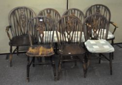 A set of seven wheel back dining chairs with removable cushions,