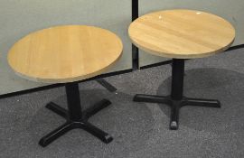 A pair of round topped cast metal low occasional tables,