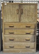 An oak cabinet with two doors opening to reveal two shelves over four drawers,
