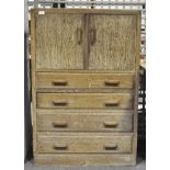 An oak cabinet with two doors opening to reveal two shelves over four drawers,