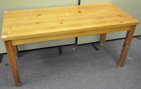 A rectangular pine kitchen table, raised on squared legs,