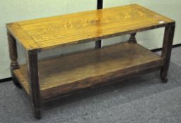 An oak two tier coffee table, raised on castors,