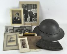 A collection of WWI and WWII photographs together with a helmet,
