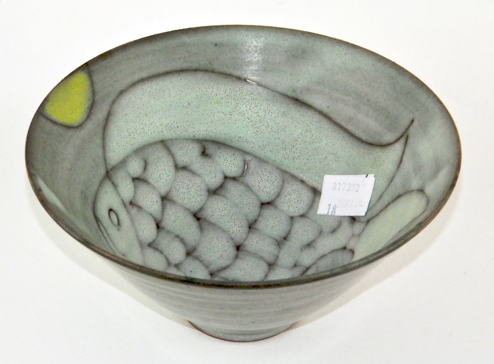 An Art pottery bowl with abstract fish decorated to the inside, marked to base 'TF', 16.