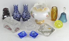 A collection of assorted glassware, mostly coloured, including a hand bell, vases,