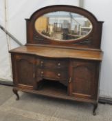 A large oak sideboard, with two central drawers flanked by two cupboards,